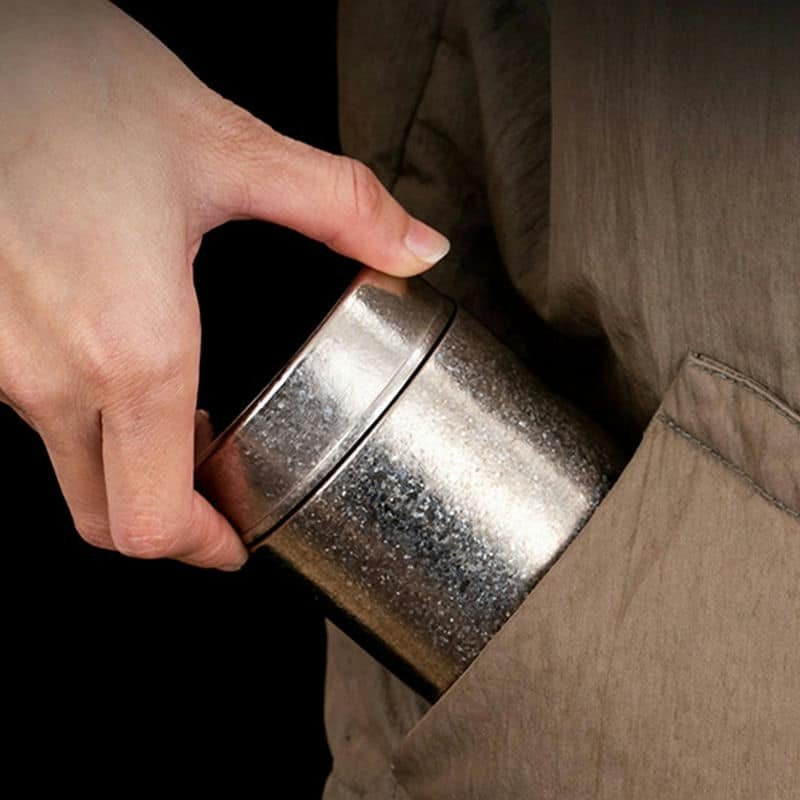 Single-wall pure titanium canister slipped into a pocket, showing how light it is